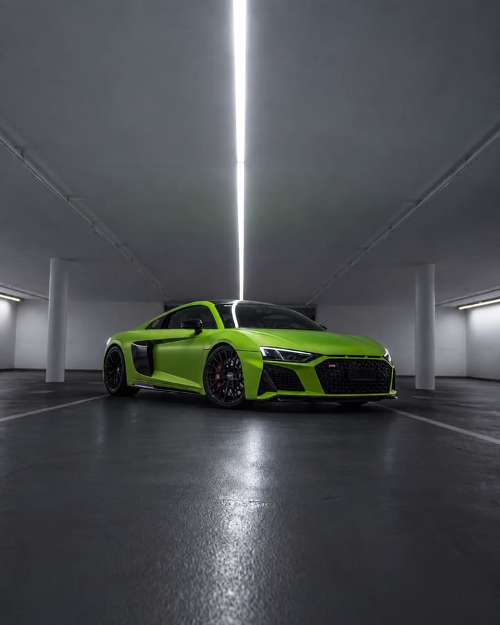 Matte green Audi R8 V10 from the front three-quarter view with black wheels and red brake calipers in an underground car park
